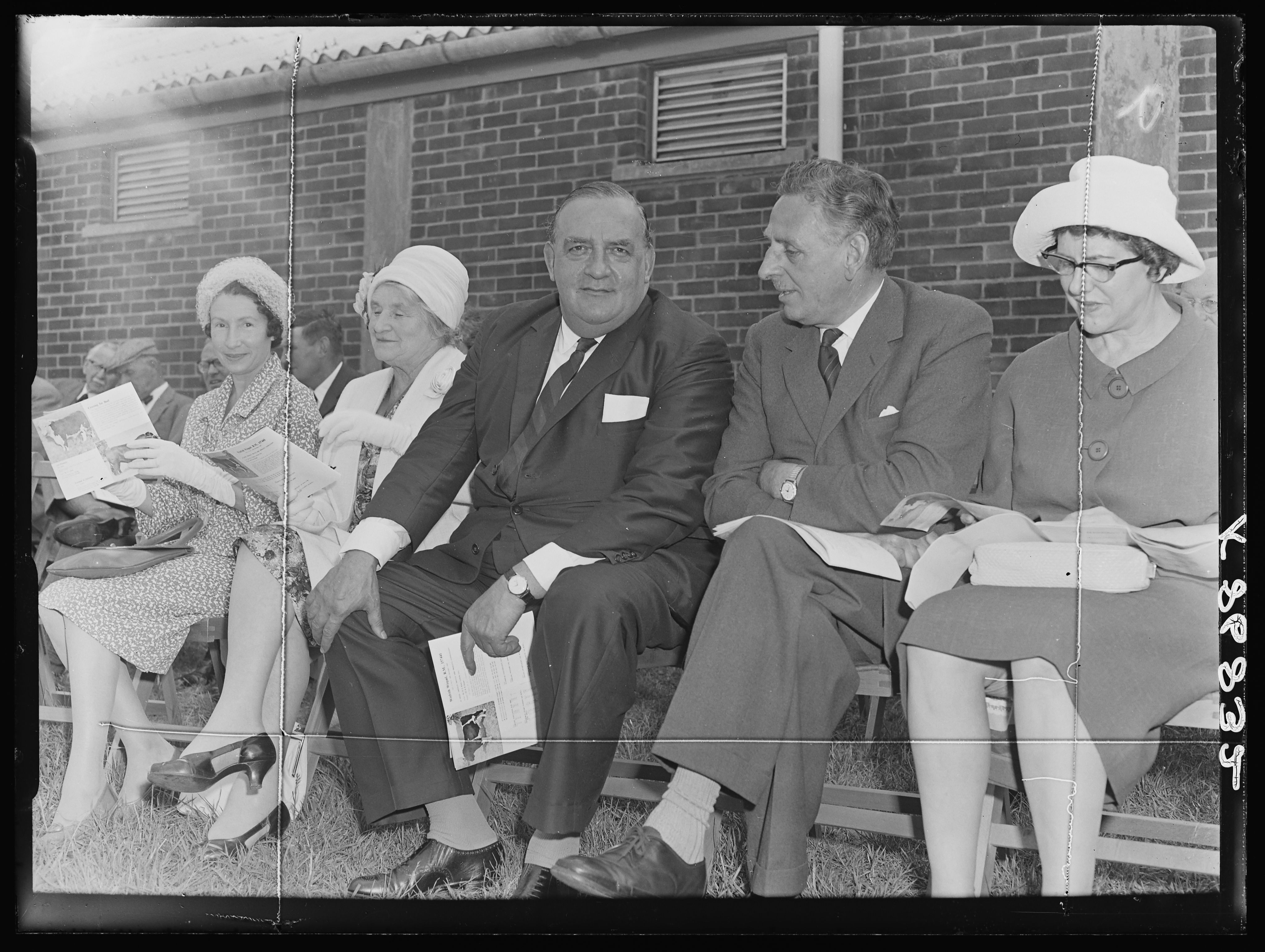 Black and white image of farmers and their wives at a cattle market
