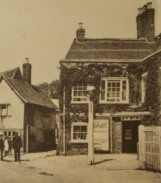 Photograph of old public house with a pole and a golden ball on top of it