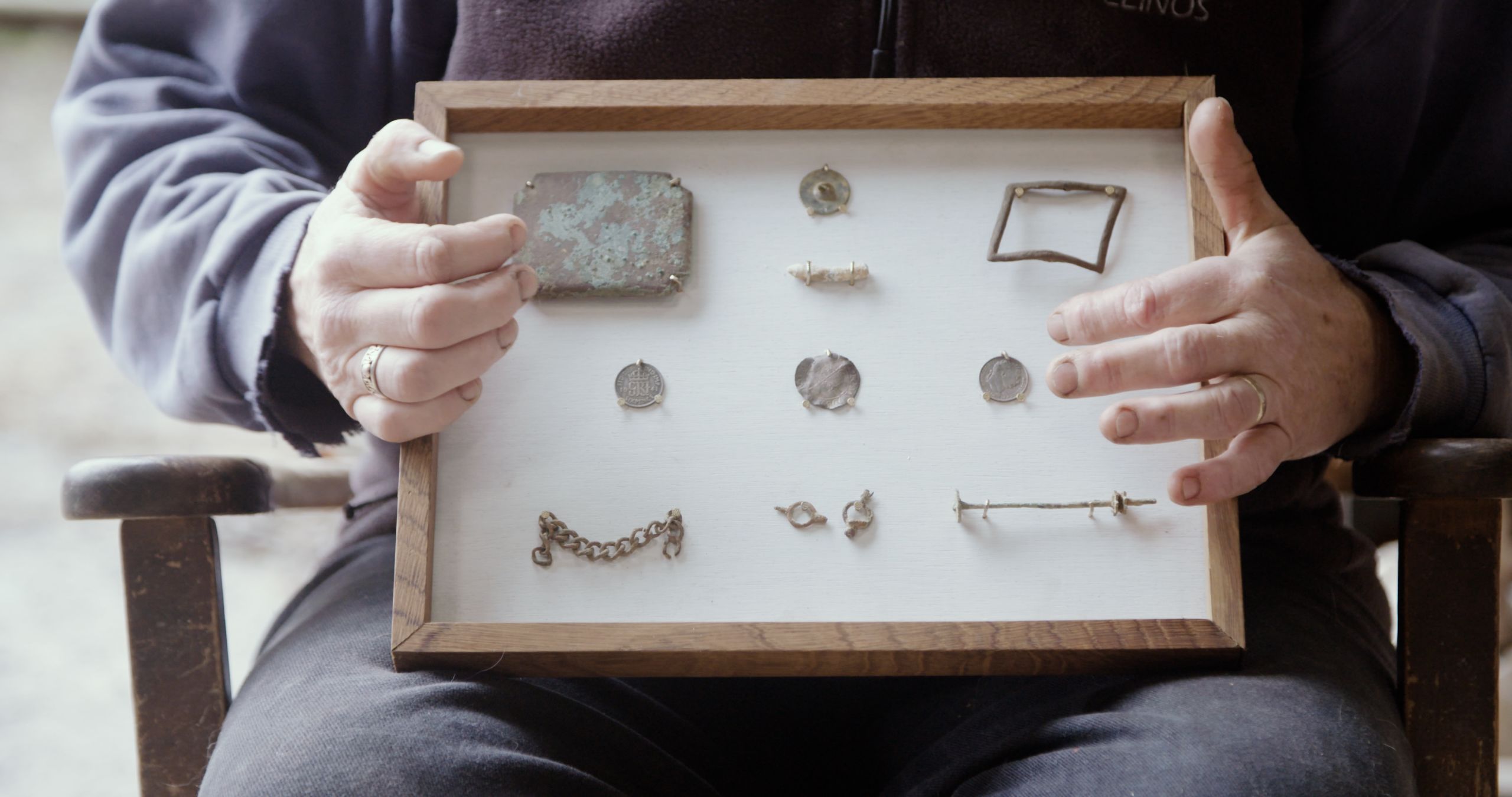 Female farmer holding a glass case of old objects